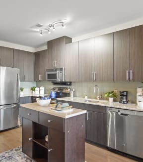a kitchen with dark cabinets and stainless steel appliances at Heights at Glen Mills, Glen Mills, PA