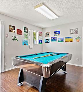 A pool table in a room with pictures on the wall. at Canyon Shadows Apartments, Riverside, 92503