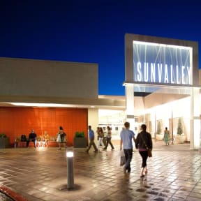 people walking outside of a sun valley mall at night