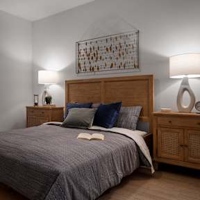 A bedroom with a large bed and a wooden headboard.