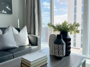 a living room with a couch and a table with a vase
