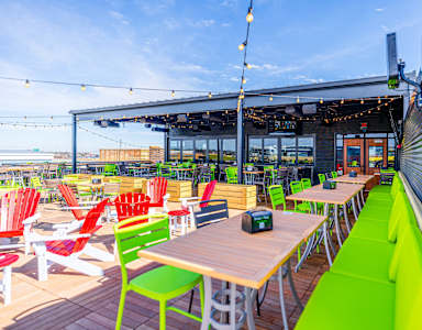 A restaurant with a wooden table and green chairs.
