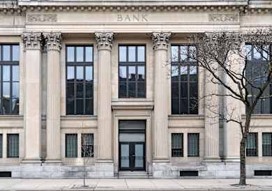 A bank building with a tree in front.