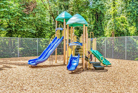 A playground with a blue and green slide and a yellow structure.