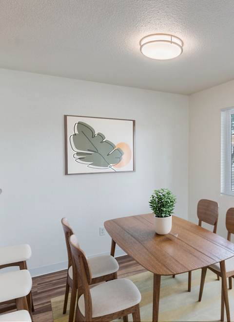 A dining room with a wooden table and chairs.