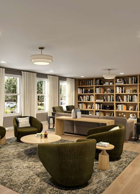 A living room with a grey sofa, a grey armchair, a coffee table, a television, and a kitchen in the background.