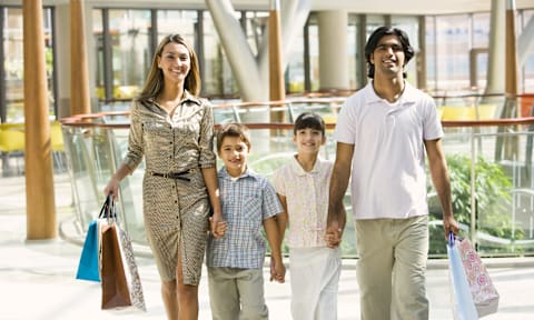 A family of four walking together holding hands.