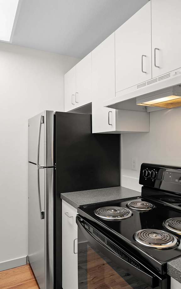 a kitchen with white cabinets and a stove and refrigerator