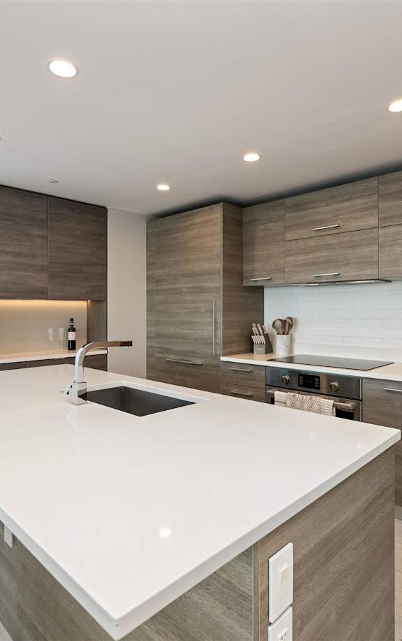 A kitchen with white cabinets and a white counter top.