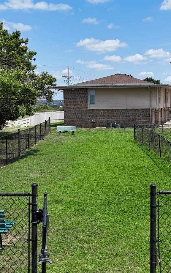 A park area with a lawn, trees, and a picnic table.