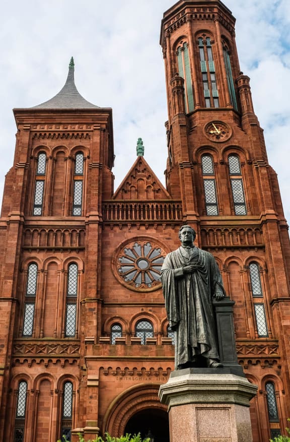 a large brick building with a statue in front of it