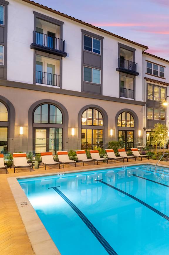 A large swimming pool in front of apartment buildings.
