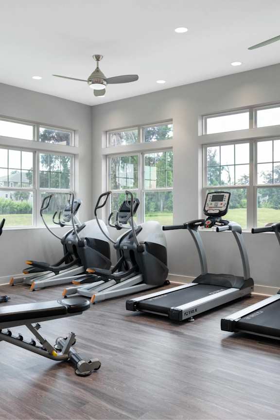 A gym with treadmills, exercise bikes, and other equipment.