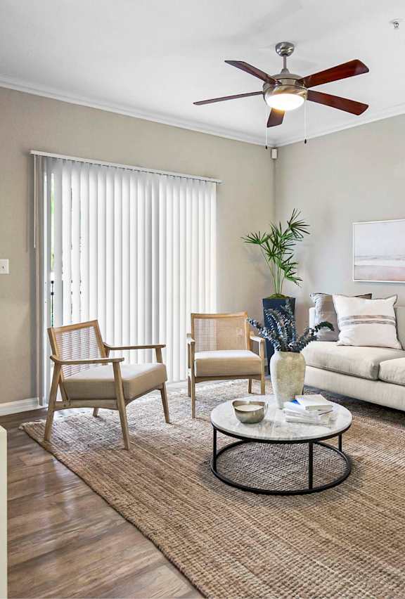 A living room with a blue couch and a glass coffee table.
