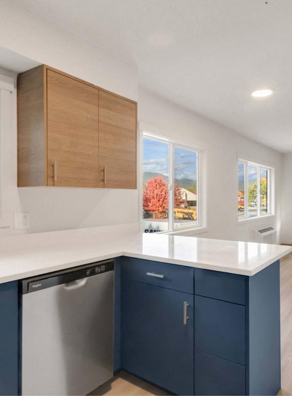 A kitchen with blue cabinets and a white countertop.