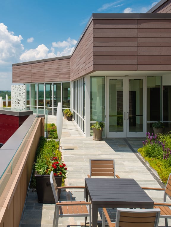 a patio with a table and chairs on the roof of a building