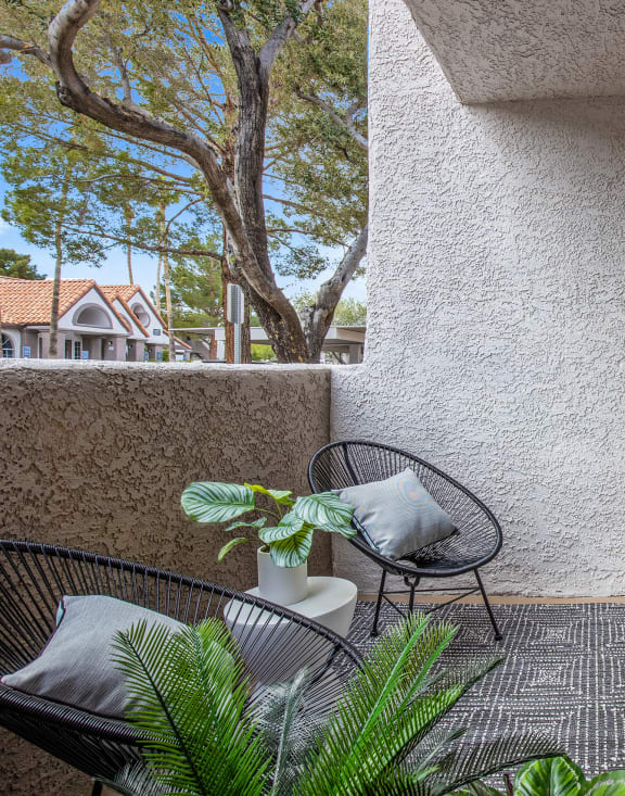 a patio with a chair and a table on a balcony