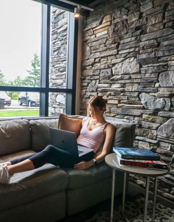 a woman relaxing on a couch while on a laptop at Bluestone Flats, Minnesota