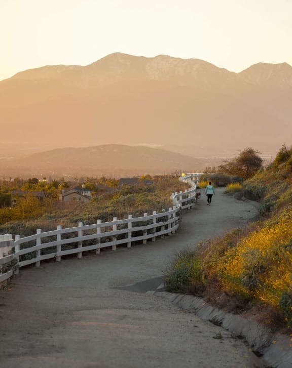 People walking down a dirt road with mountains in the background  at Legends at Rancho Belago, California, 92553