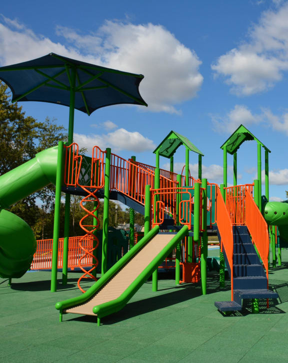 a playground with a slide and umbrella