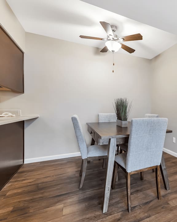 A dining room with a table and chairs.