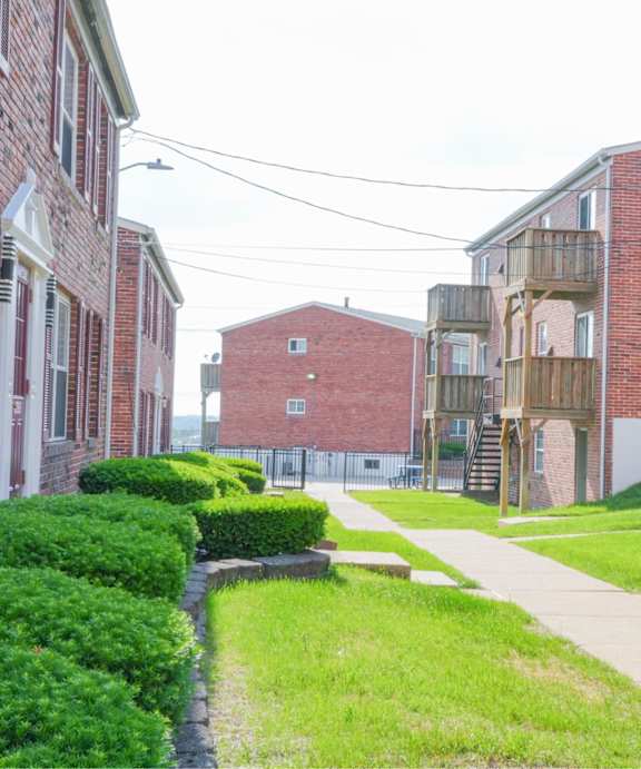 A long, narrow walkway separates two rows of apartment buildings.