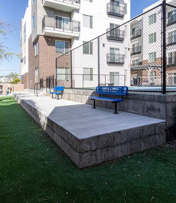 A small outdoor area with a bench and a concrete platform.