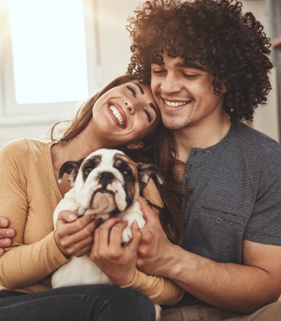 a couple sitting on the floor holding a dog