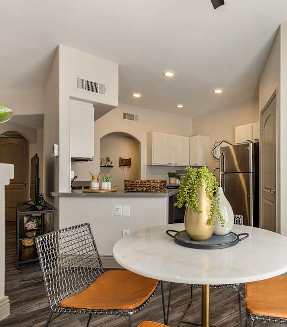 a dining room with a table and chairs and a kitchen at Mirasol Apartments, Las Vegas, NV