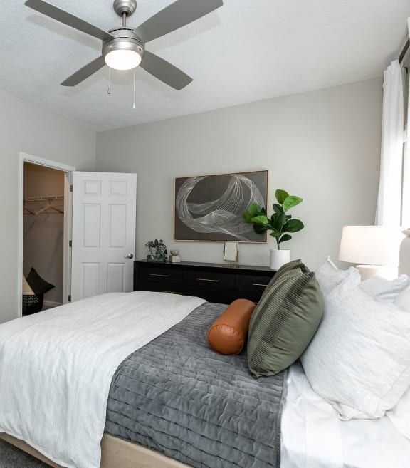a bedroom with a large bed and a ceiling fan