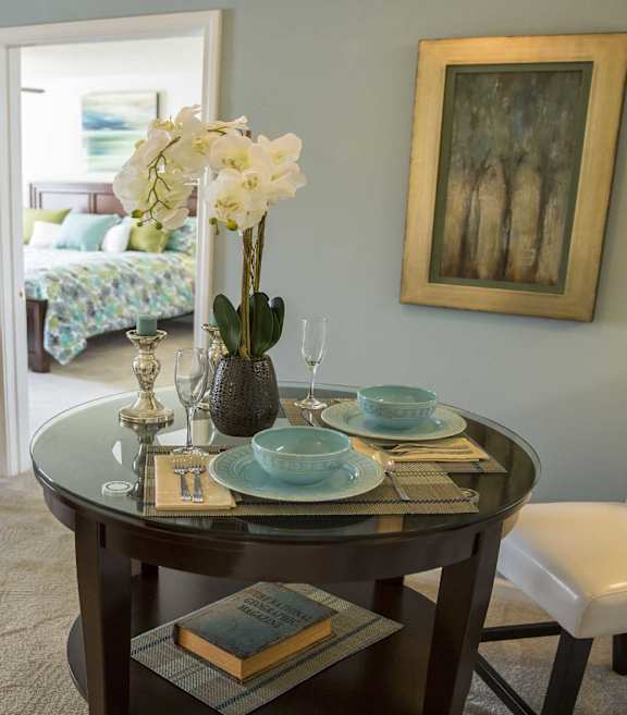 A dining room with a round table set for two.