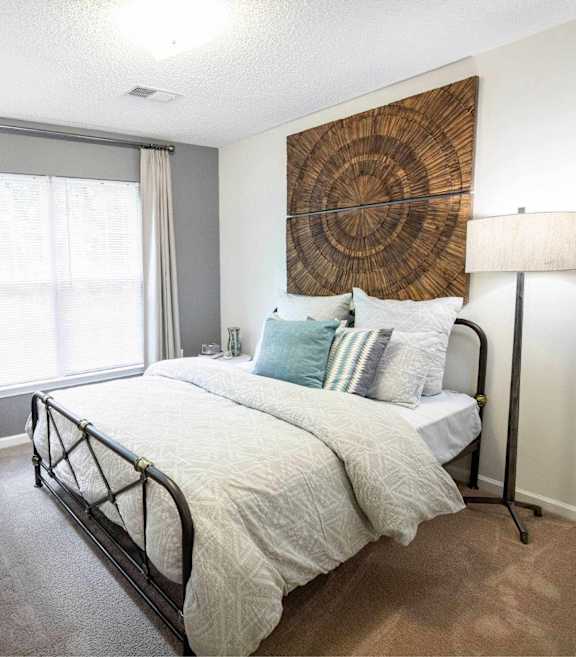 A bedroom with a large bed and a wooden dresser.