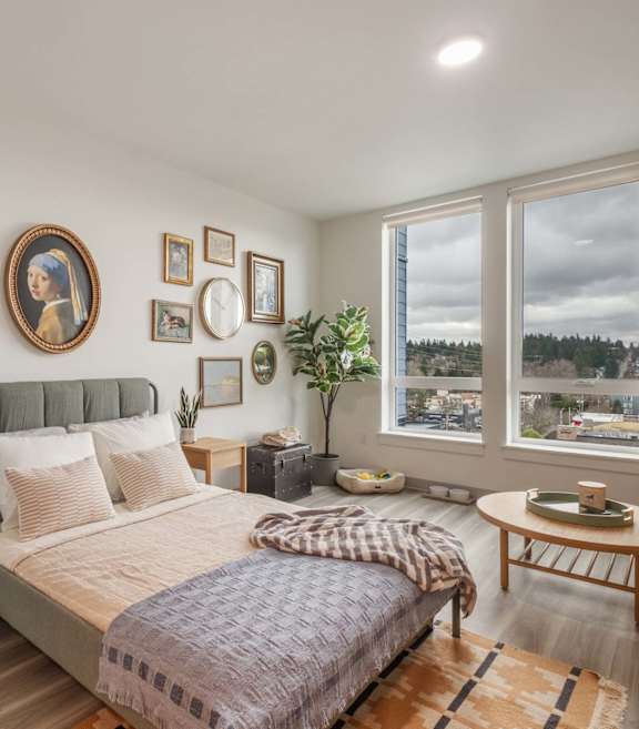 a bedroom with a large window and a bed and a desk at Nook at Northaven at Nook at Northaven Apartments, Washington