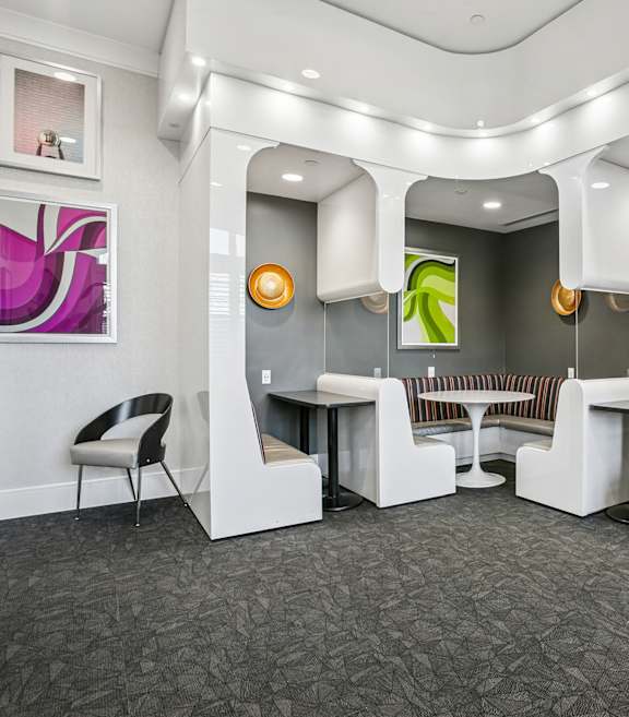 A white reception area with a grey carpet and a white chair.