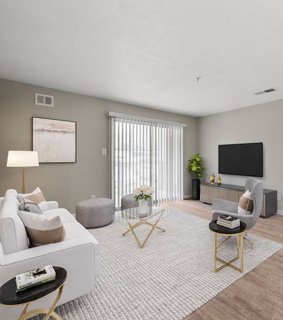 A living room with a white couch, a grey ottoman, a grey rug, a black chair, a TV, a plant, and a painting on the wall.