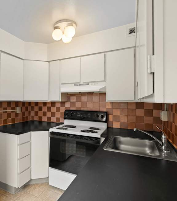 a kitchen with black counter tops and white appliances