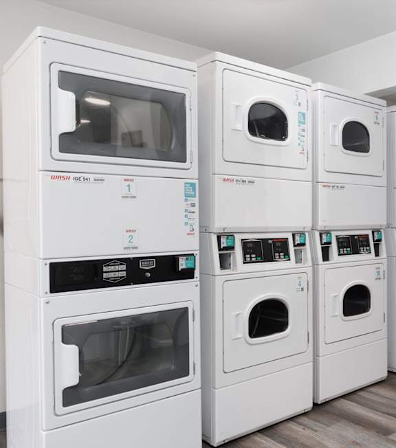 A row of white ovens are lined up in a room.
