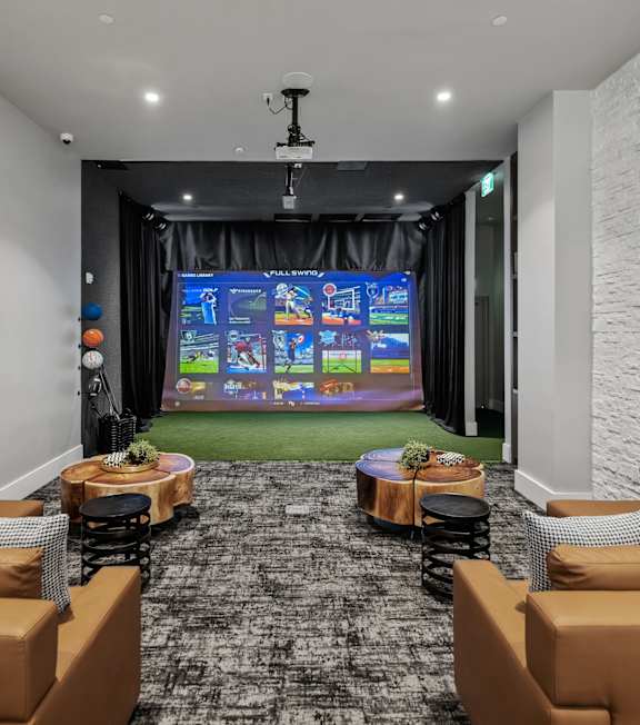 A room with a large screen and comfortable seating.