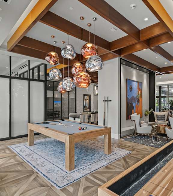 A billiard table is in the middle of a room with a pool table.