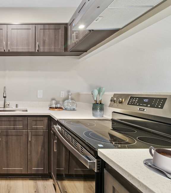 A modern kitchen with dark wood cabinets and stainless steel appliances.