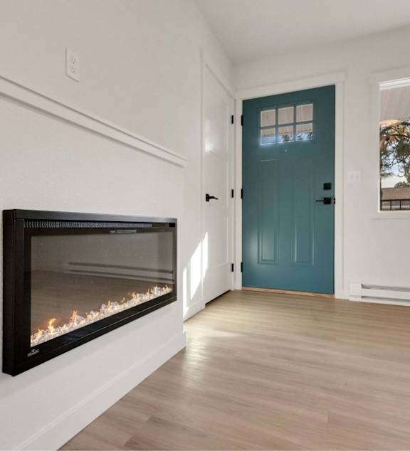 A room with a fireplace and a blue door.