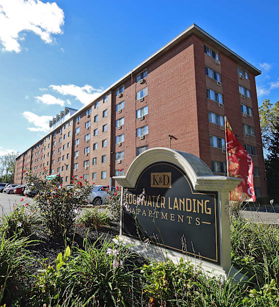 A building with a sign that says "K&D Water Landing Apartments" in front of it.