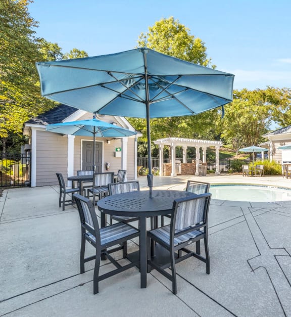 a patio with an umbrella table and chairs and a pool at Marina Point, Chattanooga Tennessee