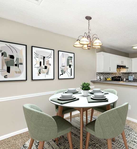 A dining room with a table set for two and a kitchen in the background at The Vistas, Macon, GA