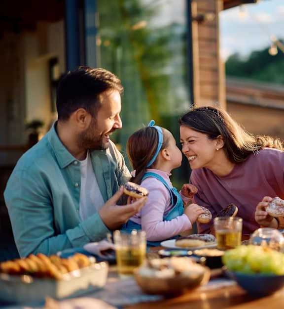 A family enjoying a meal together at a table with various dishes and drinks.