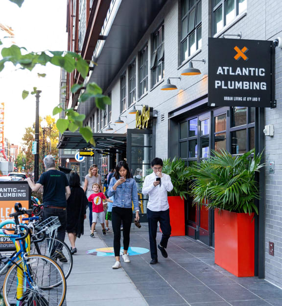 people walking down a sidewalk in front of a building