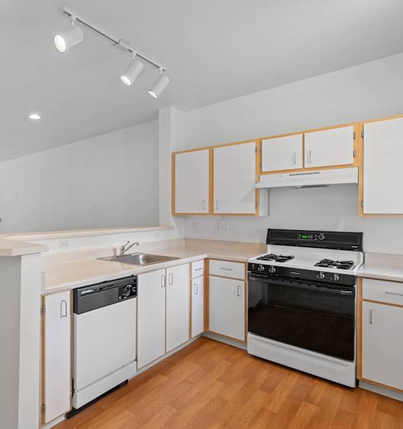a kitchen with white cabinets and a stove and a sink