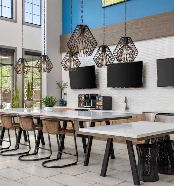 A modern dining room with a long table and chairs.