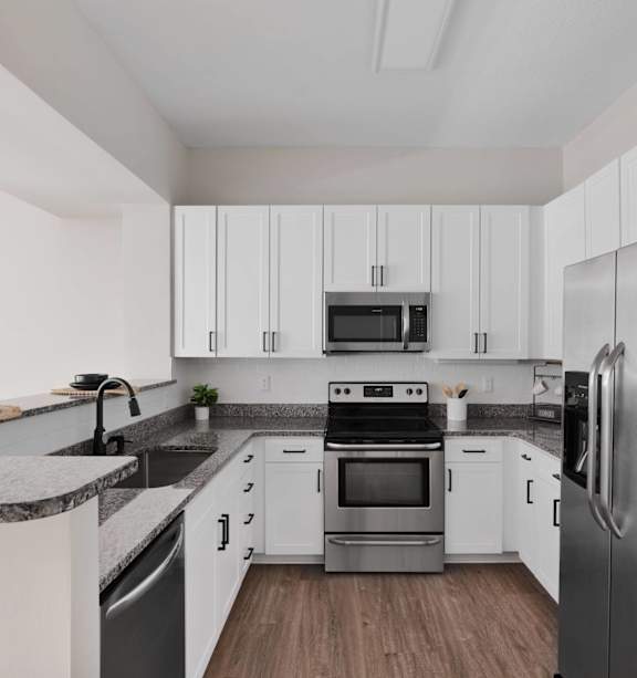 A modern kitchen with stainless steel appliances and white cabinets.