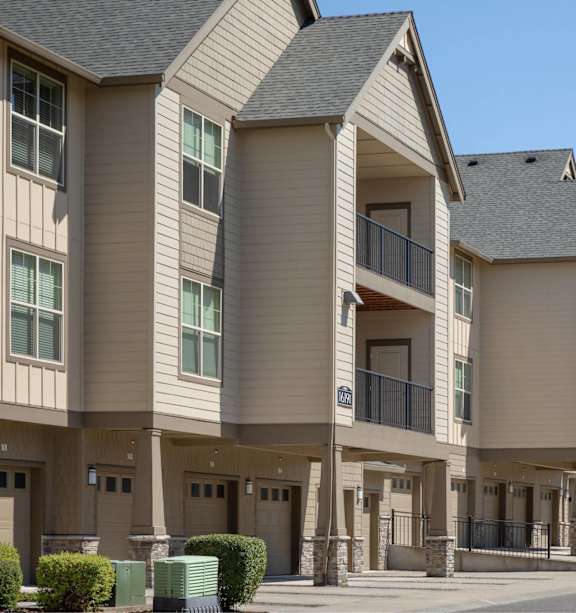 A row of modern townhouses with balconies and garages.